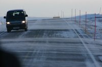 Wind blows snow across road